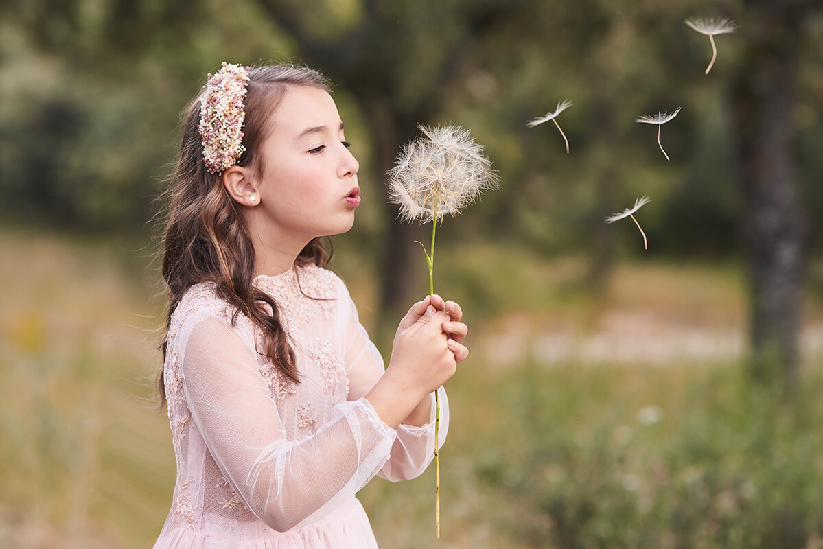 Niña sesión de fotos de comunión en Madrid diente de león Fotos de comunion en Madrid en la naturaleza