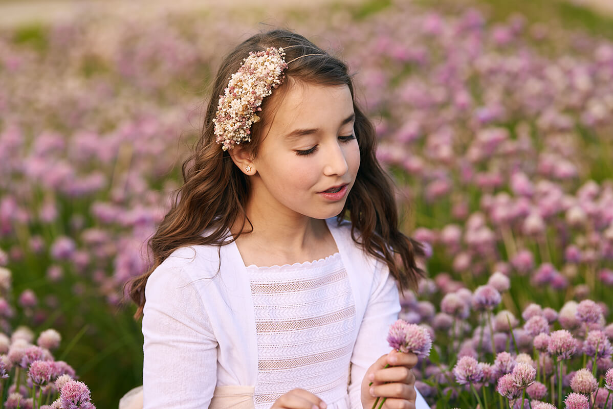 Niña sesión de fotos de comunión en Madrid campo flores Reportaje de fotos de comunion en Madrid