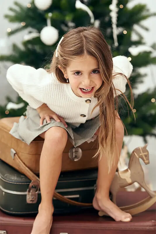Niña sentada maleta sesion fotos navidad estudio Sesion fotos navidad Madrid