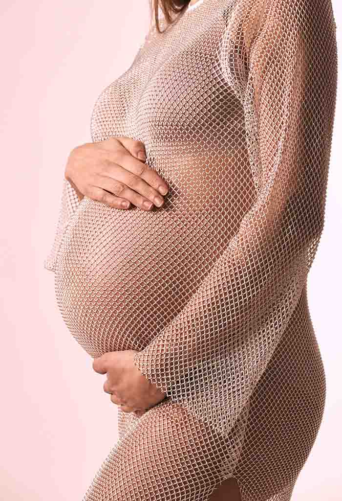 Sesión de fotos de embarazo con jumper tejido en Madrid Mujer embarazada con jumper tejido posando para una sesión de fotos en Madrid.
