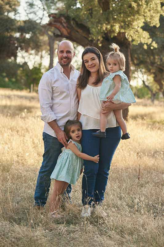 Sesión de fotos de familia al aire libre en Madrid Familia posando en el campo durante una sesión de fotos en Madrid.
