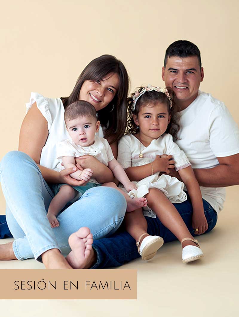 Sesión de fotos de familia en Madrid con padres e hijos sentados juntos.