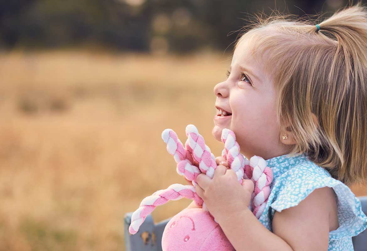Sesión de fotos de niña con juguete en el campo en Madrid Sesión de fotos en el campo en Madrid de una niña sosteniendo un juguete al atardecer.